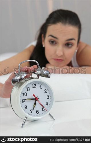 a woman stopping an alarm clock