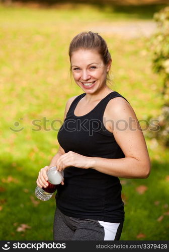 A woman taking a break from exercising in the park