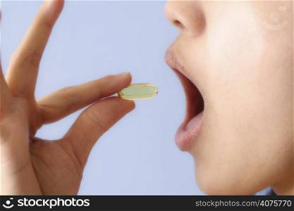 A woman taking a pill/vitamin