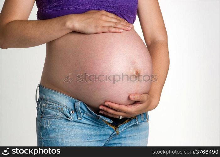 A woman tries to support her belly enduring pregnancy