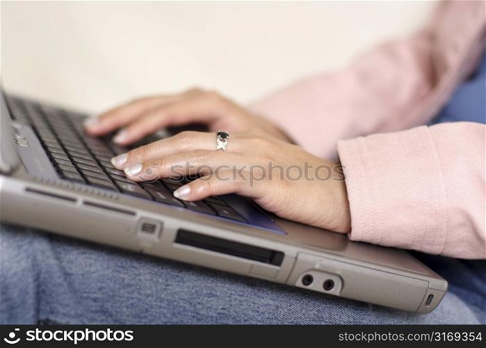 A woman typing on a laptop