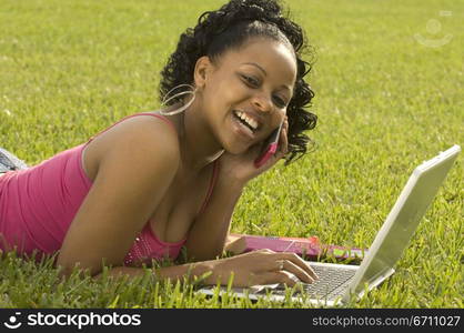 A woman using a laptop and a mobile phone