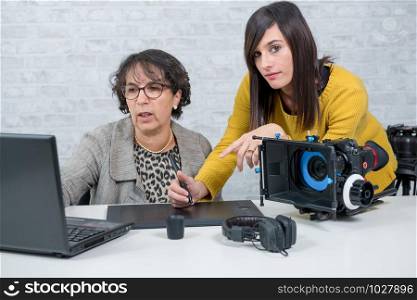 a woman video editor and young assistant using graphic tablet