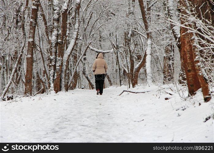 A Woman walk away alone in the winter forest outdoor