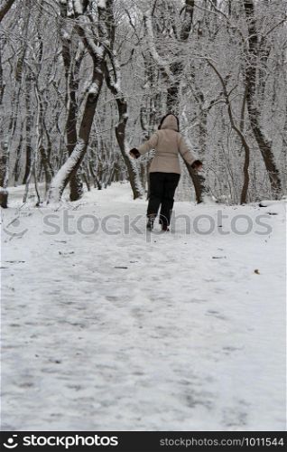 A Woman walk away alone in the winter park outdoor