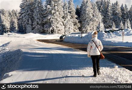 a woman walking in the snow in winter