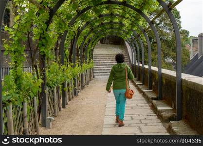a woman walking under the arbor