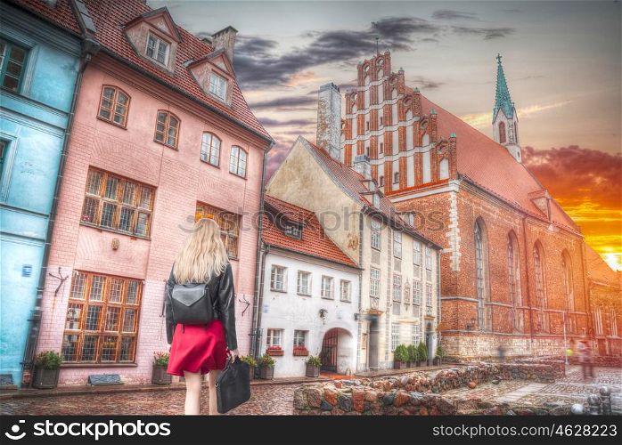 a woman walks down the street of Riga.
