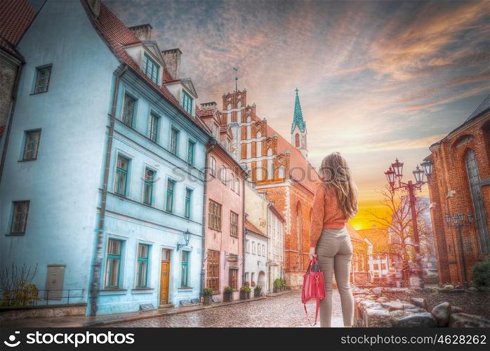 a woman walks down the street of Riga.