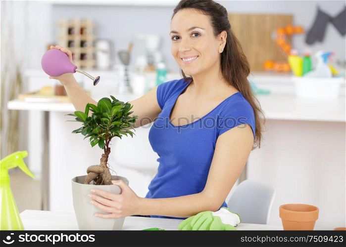 a woman watering a tree