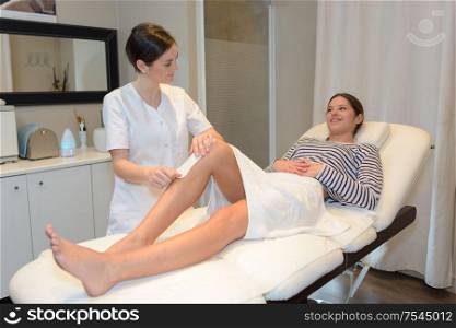 a woman waxing her legs
