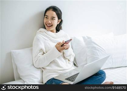 A woman wearing a white shirt playing a smartphone. Selective focus.