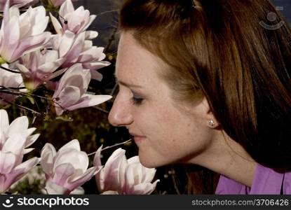 A woman who has stopped to smell the flowers