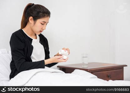 A woman who is unwell on the couch and is about to take antibiotics.