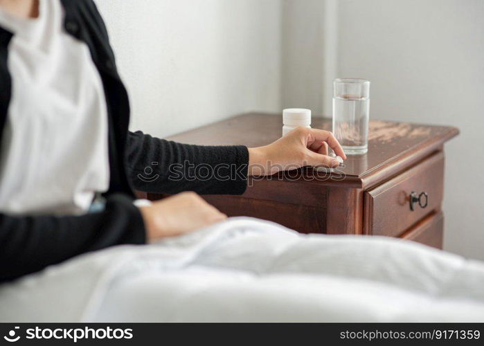 A woman who is unwell on the couch and is about to take antibiotics.