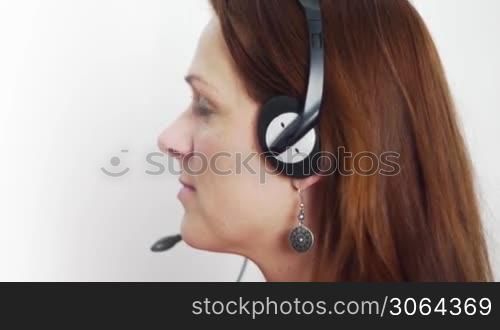 a woman with a headset turns her head to the camera and smiles, eine Frau mit einem Headset dreht sich in Richtung Kamera und lachelt