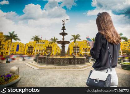 A woman with a phone walks through the center of Lima. Peru.