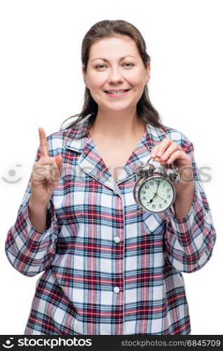 A woman with an alarm clock in her hand at 7 o&rsquo;clock in the morn. A woman with an alarm clock in her hand at 7 o&rsquo;clock in the morning