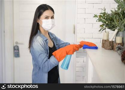 A woman with cleaning gloves using alcohol spray sanitiser to cleaning house, healthy and medical, covid-19 protection at home concept .. A woman with cleaning gloves using alcohol spray sanitiser to cleaning house, healthy and medical, covid-19 protection at home concept