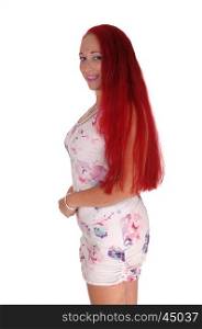 A woman with long red hair standing in profile, smiling,isolated for white background.