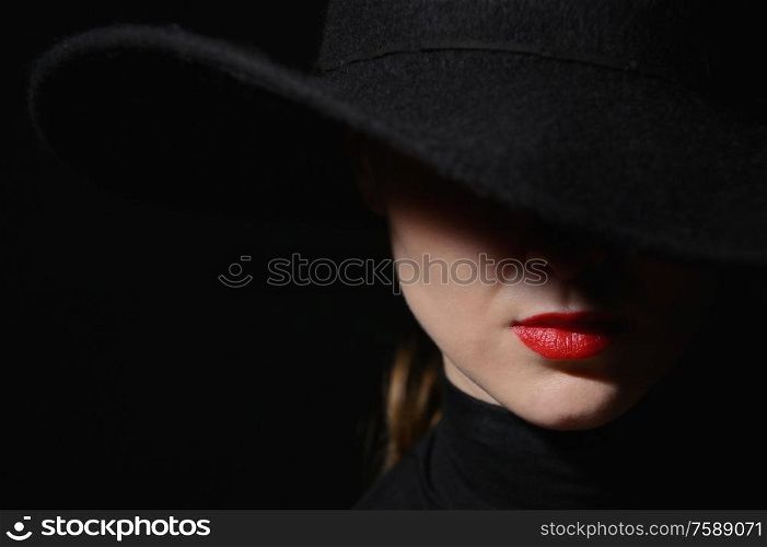 A Woman With Red Lips In A Black Hat On A Black Background