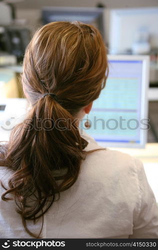 a woman working in the office at a computer screen