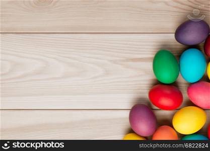 a wooden background for an inscription and a bunch of Easter eggs in the corner