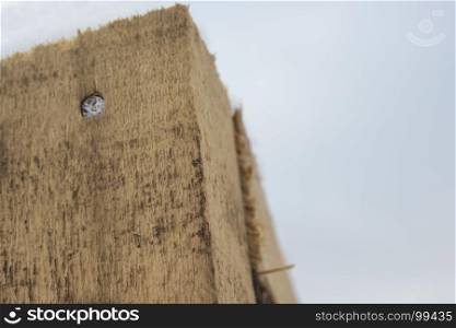 A wooden beam with a nail