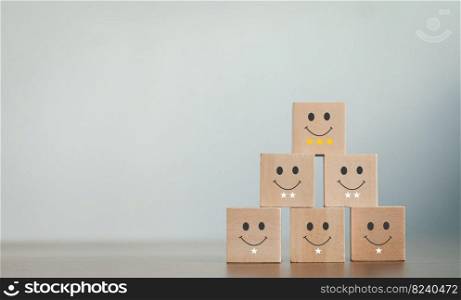 A wooden blog on customer service assessment concepts and satisfaction surveys. The customer selects a smiley face icon and a star symbol lined up on the upper wooden block of the wooden cube on the table.
