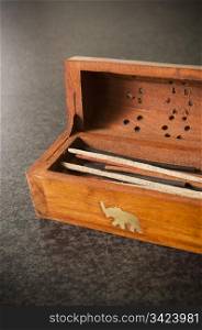 A wooden box holds incense sticks