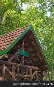 A wooden cabin with walking boots and walking stick in a forest