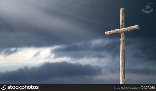 a wooden cross on a dramatic autumn sky in the rays of light