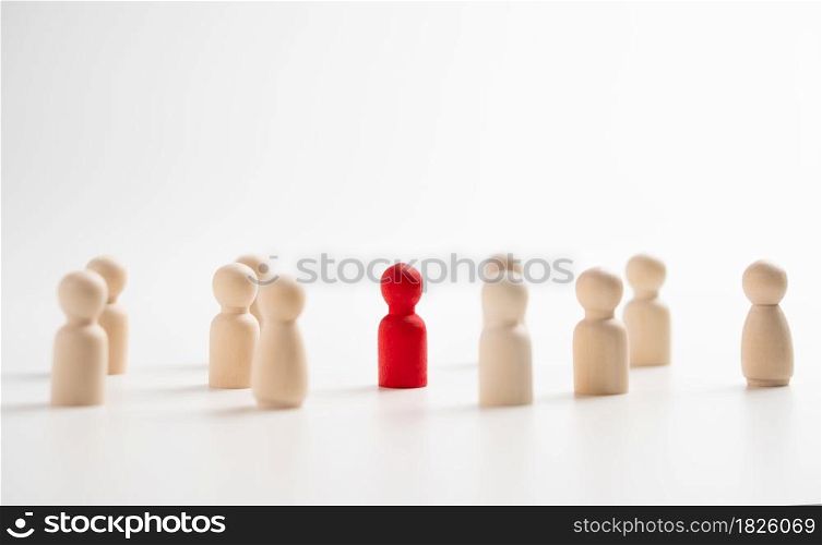 A wooden figure standing with a team to influence and empowerment. Concept of leadership, successful competition winner and Leader with influence and Social distancing for a new normal lifestyle