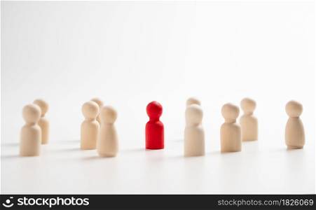 A wooden figure standing with a team to influence and empowerment. Concept of leadership, successful competition winner and Leader with influence and Social distancing for a new normal lifestyle