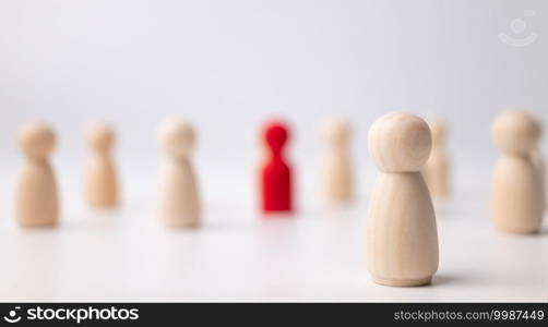 A wooden figure standing with a team to influence and empowerment. Concept of leadership, successful competition winner and Leader with influence and Social distancing for a new normal lifestyle