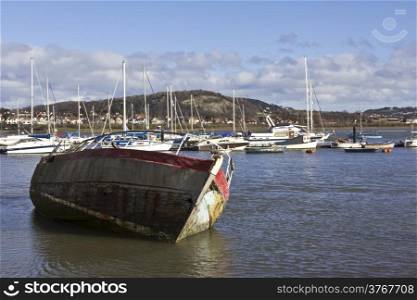 A wooden fishing boat stranded at low tide