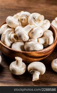 A wooden plate full of fresh mushrooms. On a wooden background. High quality photo. A wooden plate full of fresh mushrooms.