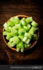 A wooden plate with a piece of celery. On a wooden background. High quality photo. A wooden plate with a piece of celery.
