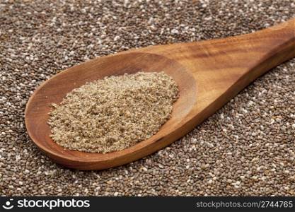 a wooden spoon of organic ground chia seeds against the whole seeds background