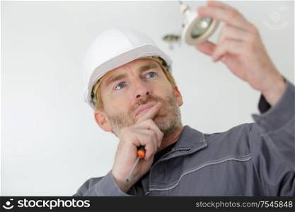 a worker checking a lamp