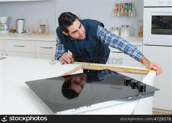 a worker measuring the kitchen workplace