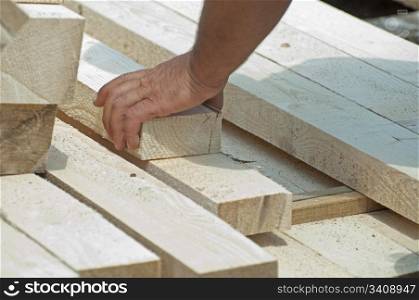 A worker moves a wooden beam