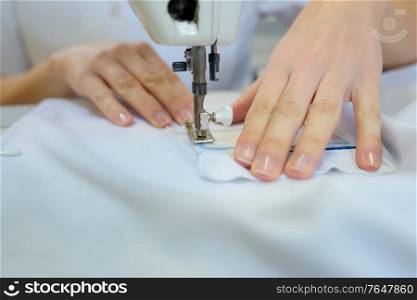 a worker sewing a fabric