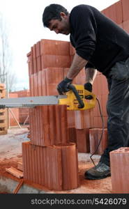 A workman using a chainsaw