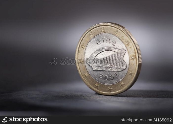 A Worn Irish Euro coin on grey. Short depth of field.