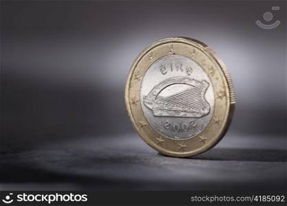 A Worn Irish Euro coin on grey. Short depth of field.