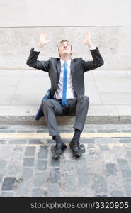 A worried business man sitting on some stairs