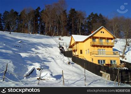 A yellow house in the snow, Brasov, Transylvania, Romania.