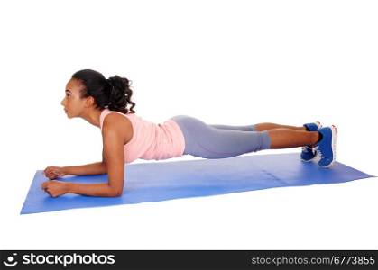 A young african american girl lying on a yoga mat, doing punch-ups, in bluetights, isolated for white background.