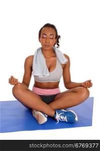 A young african american girl sitting in sports wear on a mat in a yogaposition with eye&rsquo;s closed, isolated for white background.